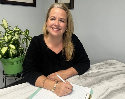 ann about us home Ann Vermette, Licensed Counselling Therapist, smiling at her desk